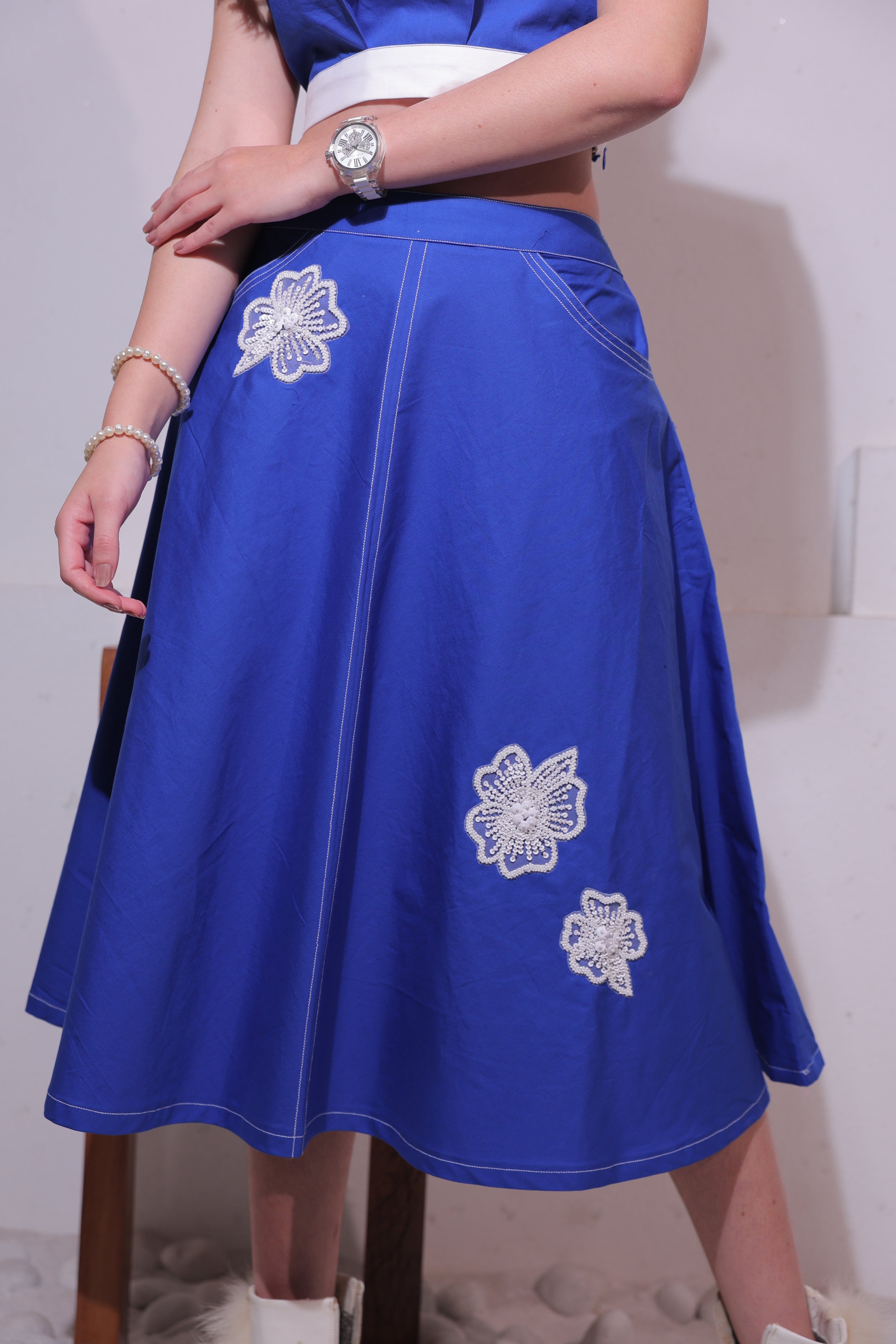 A woman wearing a Blue dress with white floral embroidery