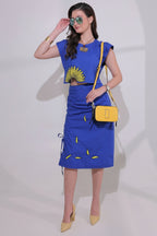 Woman wearing a blue dress with yellow accents on a white background