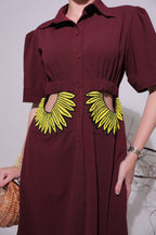 Maroon shirt dress with yellow sunflower designs on a plain background
